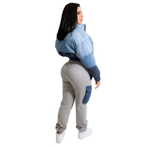 Detail view of denim patchwork cropped jacket and matching grey cargo sweatpants on model