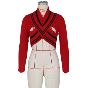 Detail of red knit cropped bolero featuring black contrast stripes and V-neck cross design