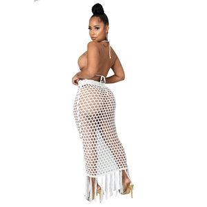 Détail d'un ensemble deux pièces en crochet blanc avec haut licou et jupe longue ajourée