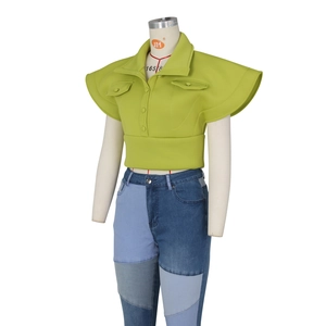 Detailed view of apple green stand-collar top with ruffled sleeves and patchwork jeans