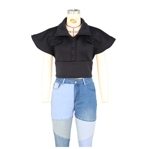 Detail of black short sleeve polo shirt with oversized collar and front pocket decor