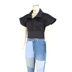 Detail of black polo top with flutter sleeves and blue patchwork denim jeans on mannequin