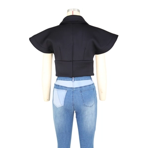 Detail view of black sleeveless top featuring dramatic tiered ruffles and high stand collar