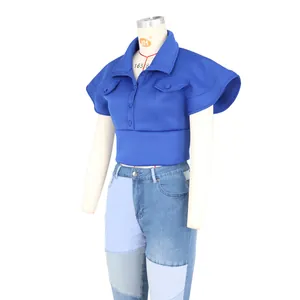 Detail of royal blue stand collar vest with structured cap sleeves and flap pockets