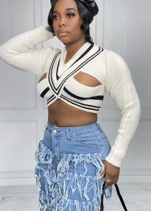 Detail of V-neck striped knit crop top featuring a crisscross cutout neck design