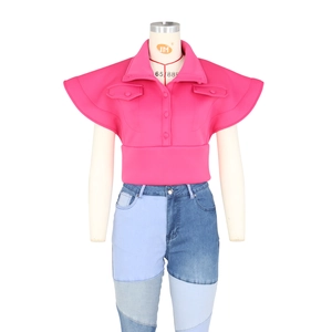 Detail of crop top with flutter sleeves and high-waist patchwork denim pants