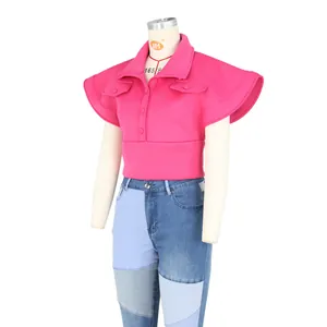 Detail of bright pink crop top with large ruffle sleeves and lapel collar design