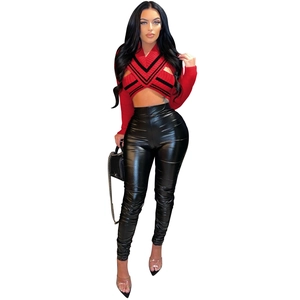 Detail of red V-neck cropped knit sweater with hollow-out pattern and chain bag