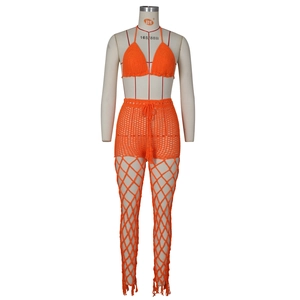 Detail of orange crochet three-piece swimsuit showing intricate hollow-out mesh knitting