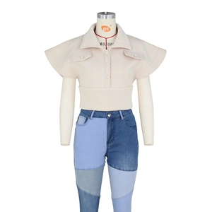 Detail of cream short top with flared cape sleeves and unique shoulder silhouette