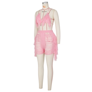 Détail de l'ensemble tricoté rose avec haut bikini licou et short à franges et pompons