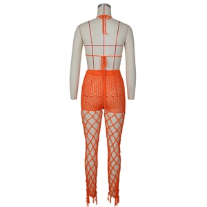 Detail of crochet fringe hem and mesh hollow-out knit pants in vibrant orange beachwear