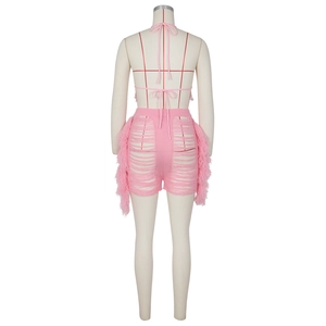 Détail d'un ensemble en maille rose avec short découpé au dos et détails de franges