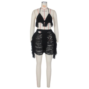 Détail du haut dos nu au crochet noir et du short à franges avec textures en maille