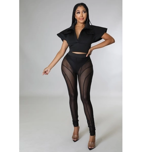 Detail of black two-piece set featuring sheer mesh geometric patchwork on high-waist trousers