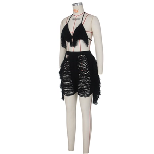 Détail de l'ensemble deux pièces en tricot noir avec franges à glands et dos nu