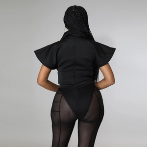 Detail of black avant-garde top with structural flutter sleeves and back zipper closure