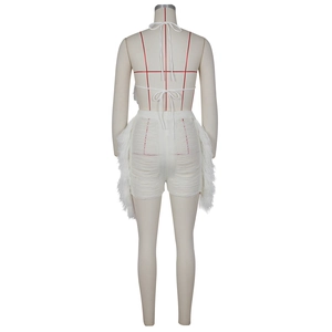 Détail d'un ensemble blanc dos nu en tricot avec shorts à franges et laçage au dos