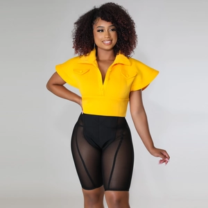 Detail of high-waist cycling shorts featuring mesh patchwork and yellow polo shirt