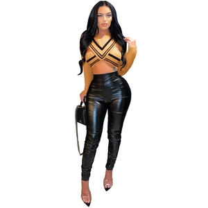 Detailed look at yellow halter knit top with chest cut-out and faux leather pants