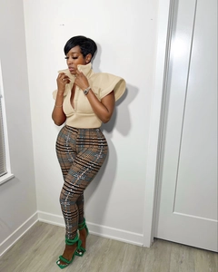 Chic beige stand-up collar vest top paired with stylish plaid trousers and green heels