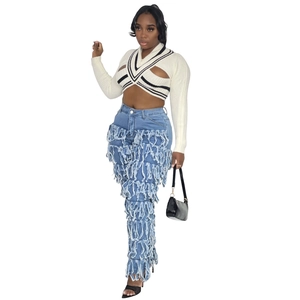 Detail view of V-neck white knit crop top with black stripes and hollow chest design