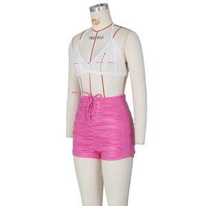 Detail view of high-waisted pink PU shorts with drawstring and pleated texture