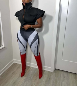 Detail of black stand collar vest with red patent leather high boots and patterned tights