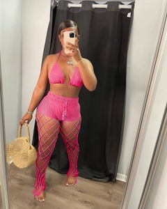 Detailed crochet texture of hot pink beach set including knit shorts and fringe trousers