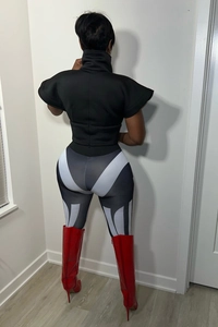 Detail view of black high neck top and geometric print leggings with red high boots