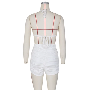 Detail view of the ruched back design and halter neck tie on white PU leather shorts set