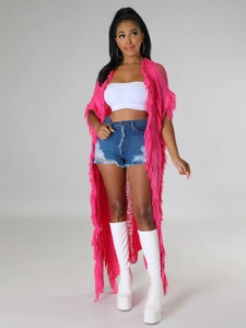 Gros plan sur le gilet en maille rose vif avec de longues franges et un design ajouré