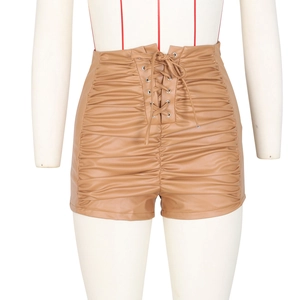 Close-up of tan high-waisted PU leather shorts featuring ruched design and lace-up front