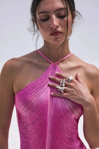 Dettaglio del top allacciato al collo rosa acceso con texture di seta e frange mobili