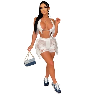 Détail d'un ensemble blanc en tricot avec haut à franges et short évidé assorti