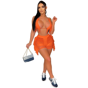 Détail du haut de bikini orange à franges et de l'ensemble short en tricot ajouré