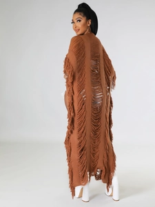 Détail macro du cardigan en maille marron avec texture ajourée et franges longues