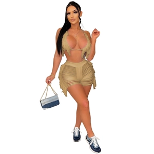 Détails de l'ensemble tricoté kaki avec haut à franges et short à pompons effet vieilli