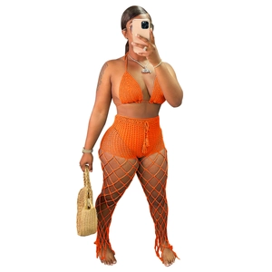 Detail of orange crochet three-piece set showing openwork mesh texture and boho beach style