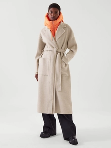 Détail de la texture du manteau en laine avec revers, poches plaquées et col orange matelassé