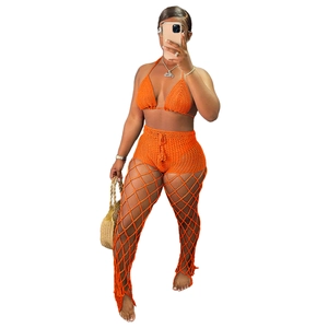 Detail of orange crochet three-piece beach set featuring hollow mesh pattern and knit texture