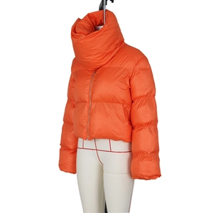 Detail of bright orange puffer jacket featuring a high stand collar and metal zipper