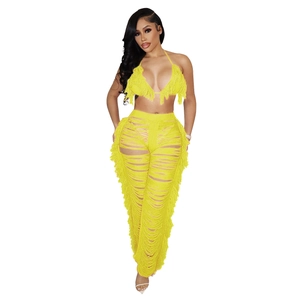 Nahaufnahme von gelbem Neckholder-Top und Fransenhose mit Cut-out-Details im Set
