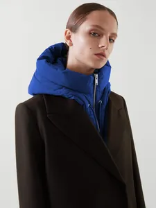 Détail de manteau en laine marron avec gilet à capuche bleu brillant et fermeture éclair