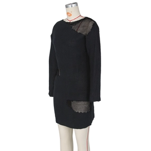 Close-up of black knit dress featuring asymmetric hollow mesh and deconstructed texture