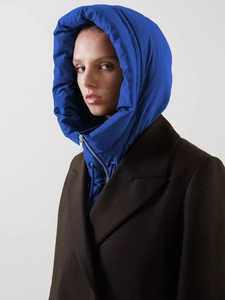 Détail d'un col à capuche matelassé bleu roi avec fermeture éclair sur un manteau