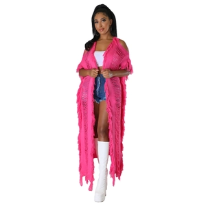 Détail du cardigan en maille rose vif avec découpes ajourées et franges de style bohème
