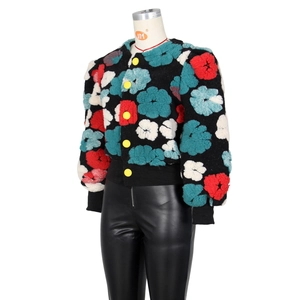 Detailed view of 3D floral flocked jacket with bold yellow buttons and leather pants