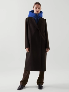Détail d'un manteau en laine marron foncé stylé avec un gilet à capuche bleu vif