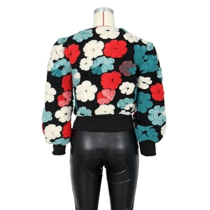 Detail view of the back of a short jacket featuring colorful 3D floral flocking patterns